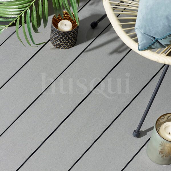 Grey wood grain composite decking with chair, candle and plant