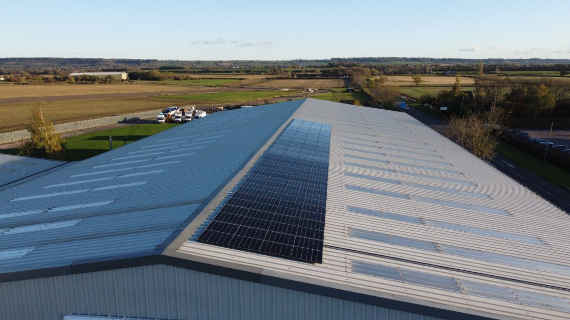 Solar array on Husqui warehouse roof with countryside view